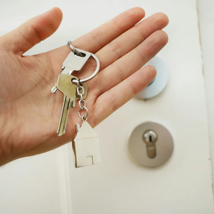 Türschlüssel in der Hand von einem Immobilienkaufmann.